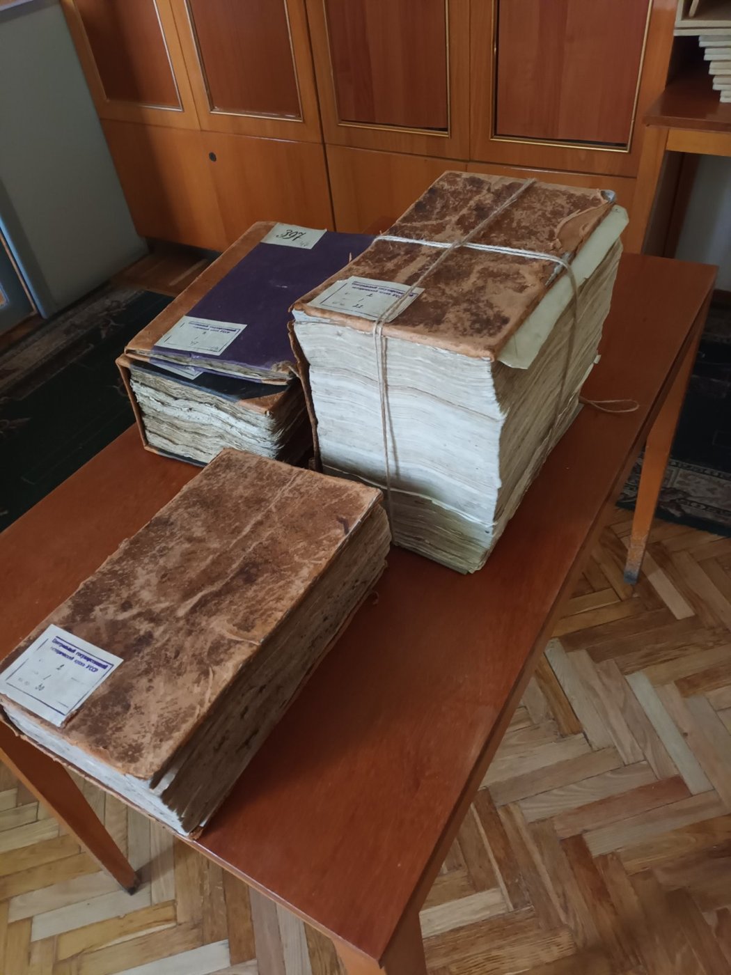 Stosy ksiąg grodzkich na stole w archiwum